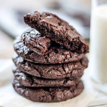 A stack of chocolate cookies, with one broken in half on top
