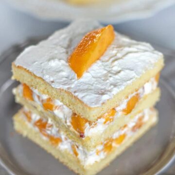 An easy sponge cake layered with fresh peaches and homemade whipped cream.