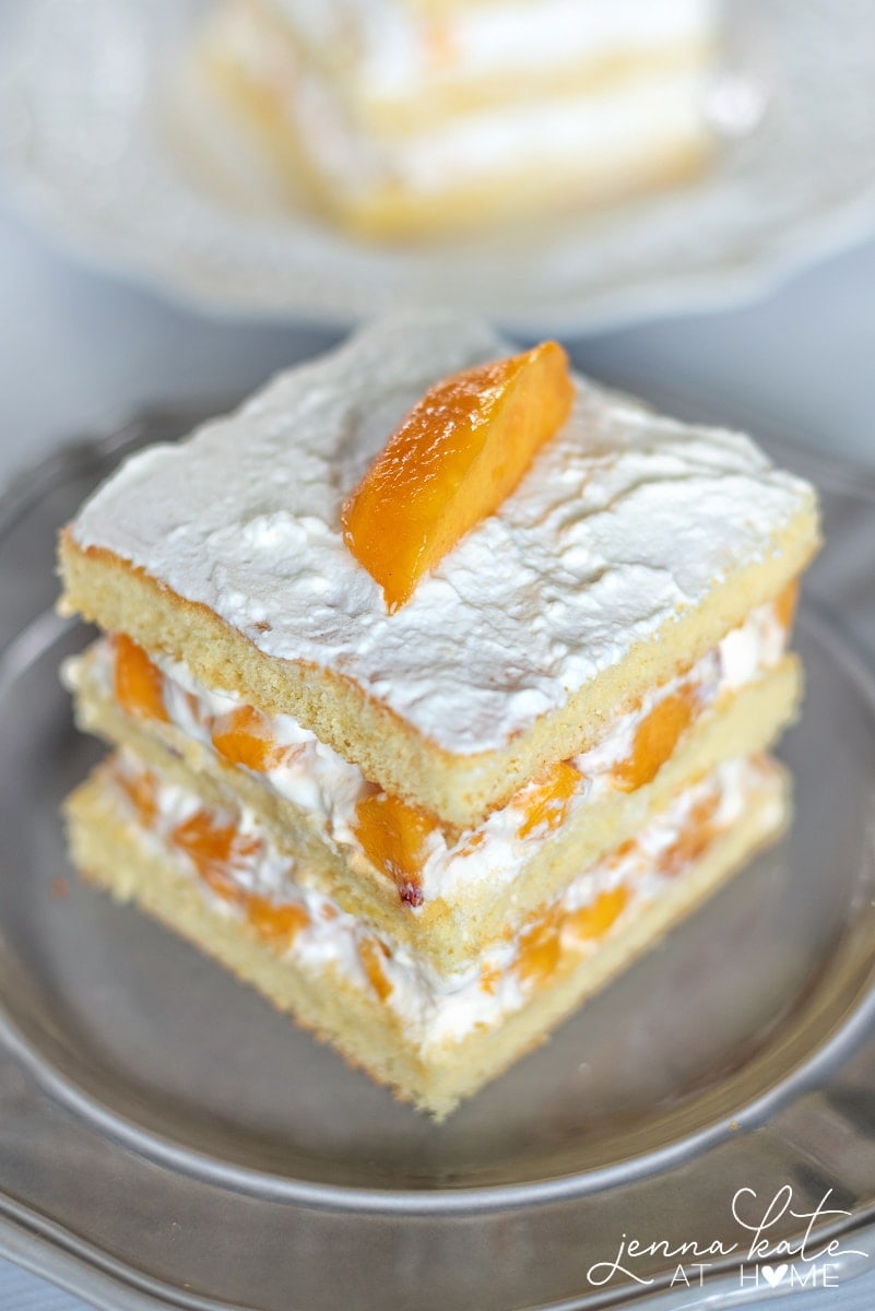 An easy sponge cake layered with fresh peaches and homemade whipped cream. 