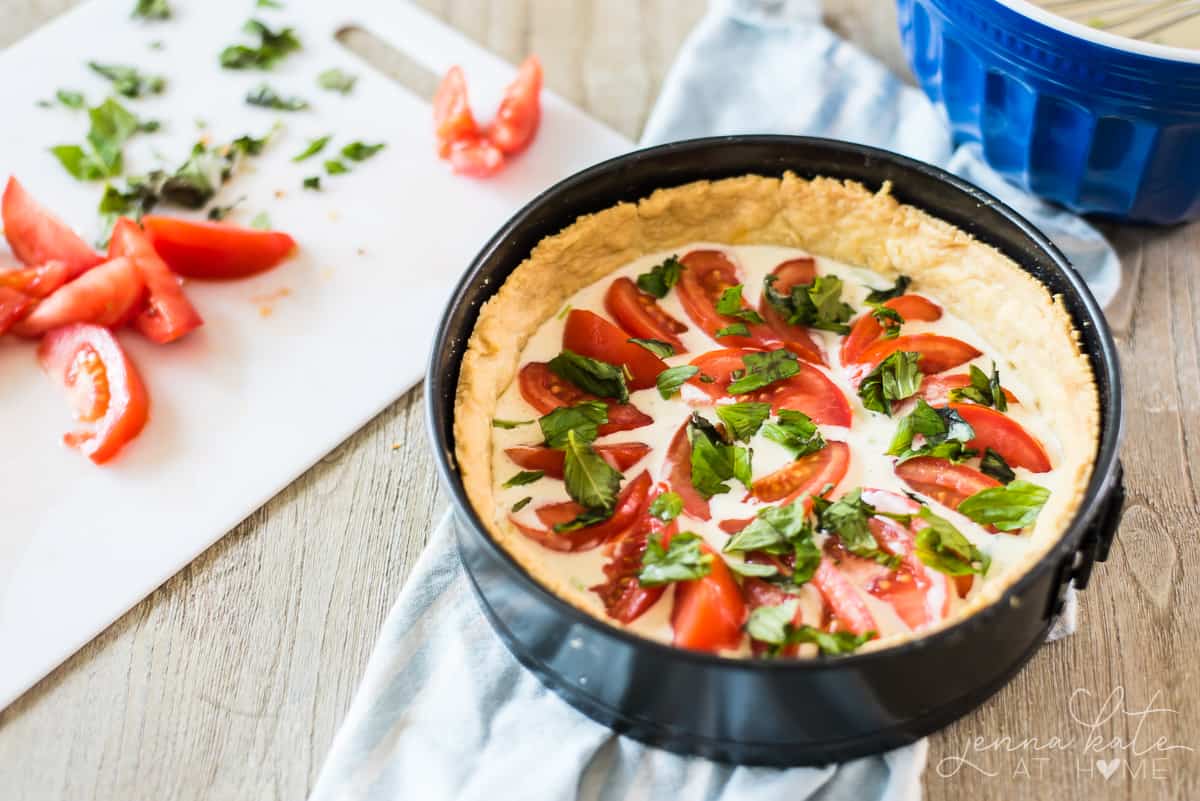 The tomato pie filling is a creamy parmesan buttermilk custard topped with basil and tomato slices