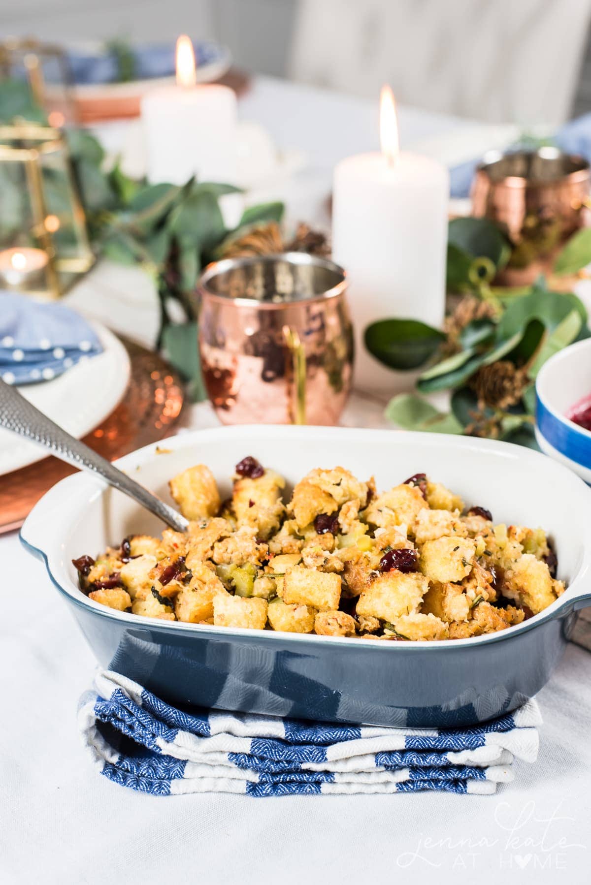 Traditional stuffing in a bowl around Thanksgiving table setting