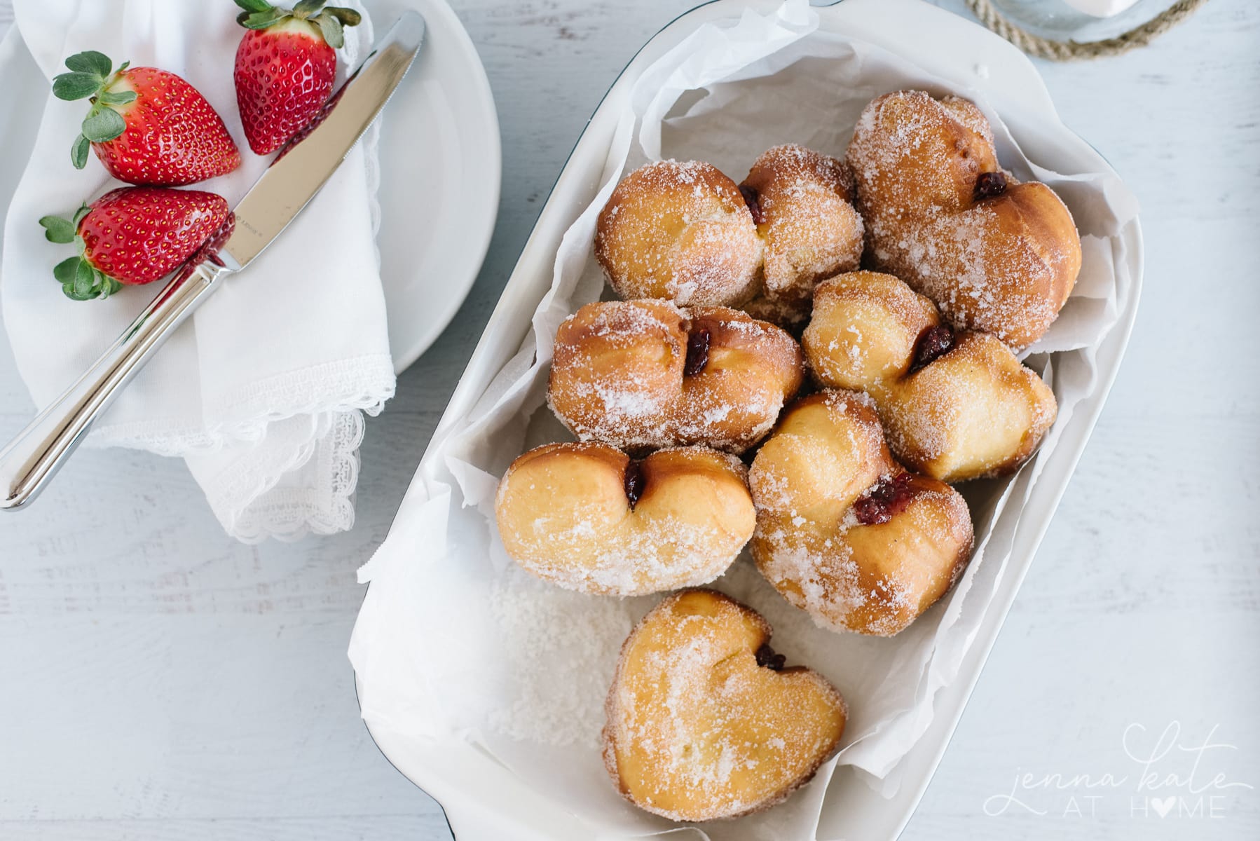 dish filled with freshly baked yeast donuts filled with jam