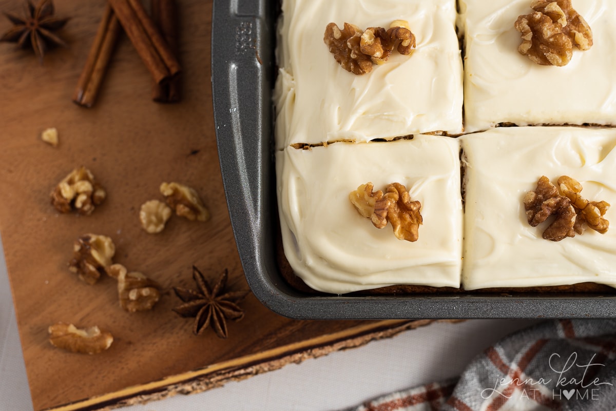 spice cake in the pan with frosting and walnuts on top