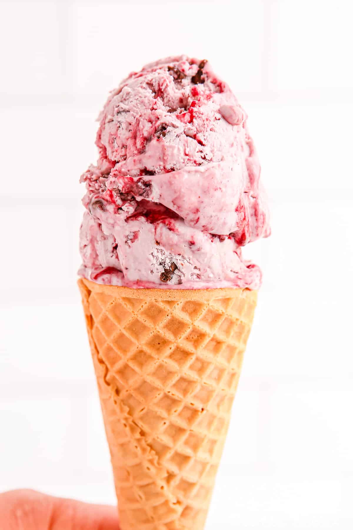 sugar cone with a large scoop of black raspberry chocolate chip ice cream