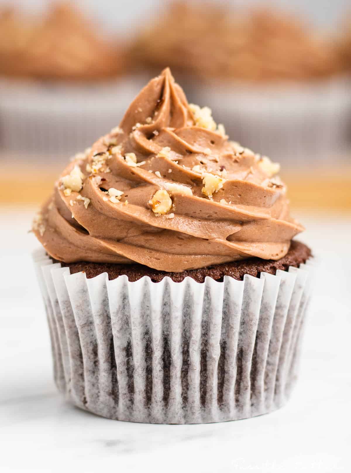 chocolate nutella cupcaked with nutella buttercream swirled on top and topped with hazelnuts