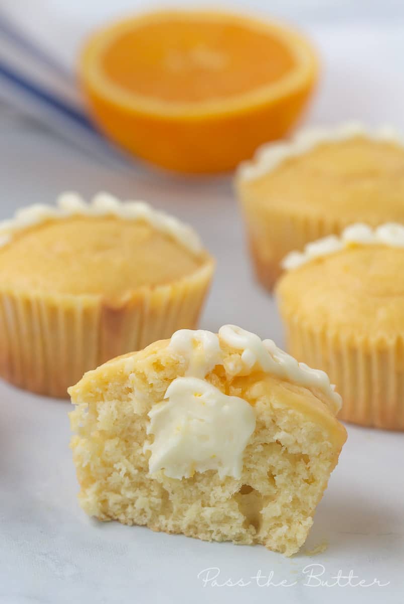a homemade hostess orange cupcake cut in half showing the filling on a marble countertop.