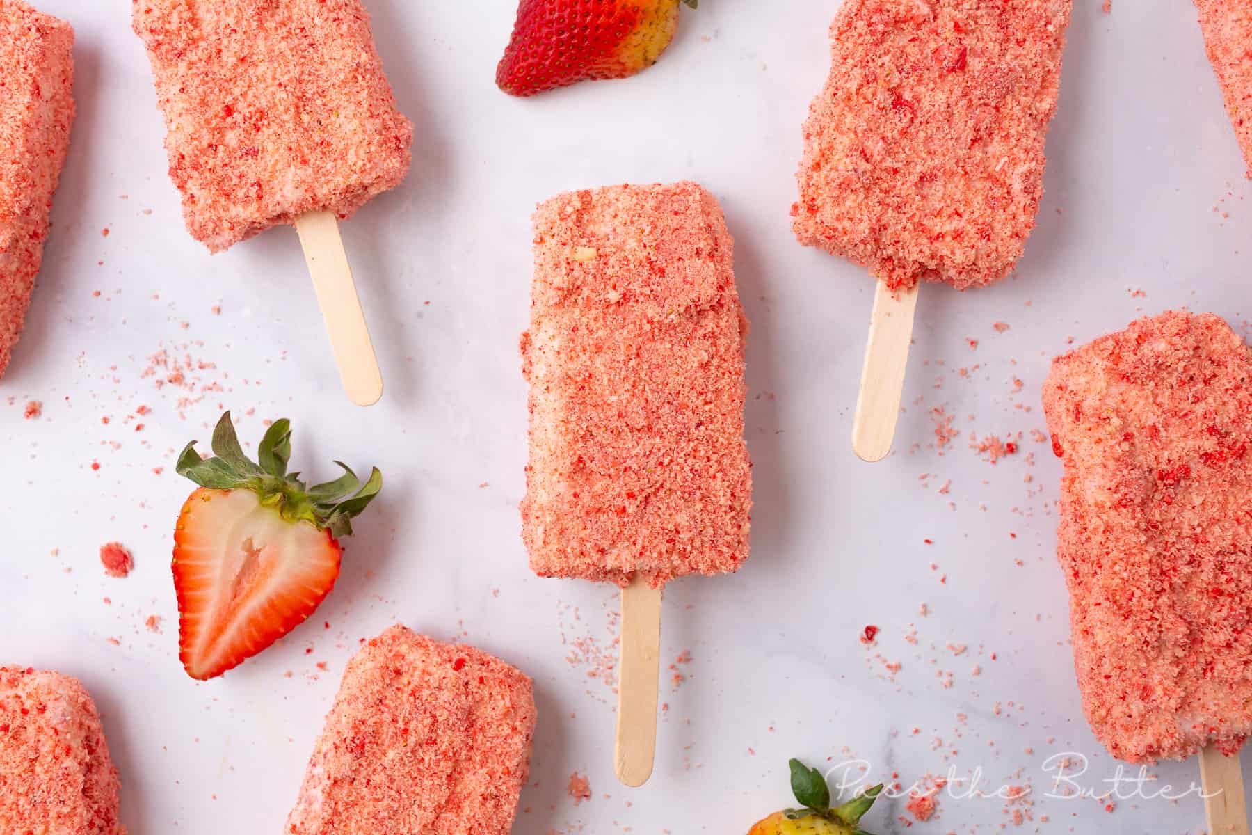 homemade strawberry shortcake ice cream bars on a baking sheet with fresh strawberries