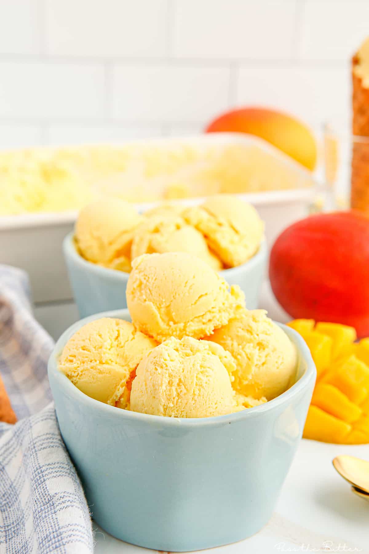 scoops of mango ice cream in a blue bowl