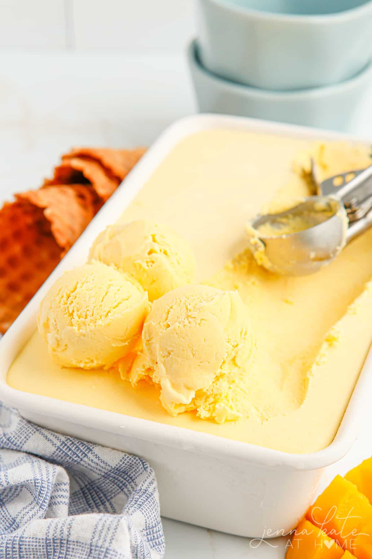 3 scoops of mango ice cream in a loaf pan filled with chilled ice cream