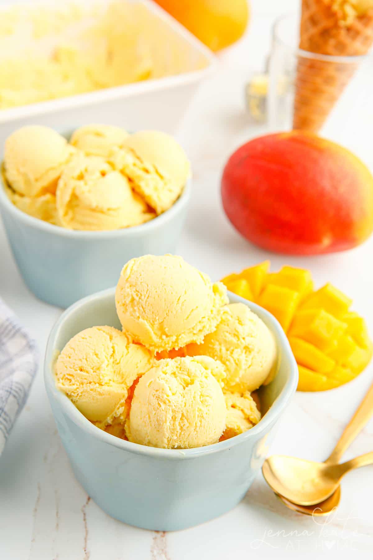 bowl of mango ice cream with mangoes in the background
