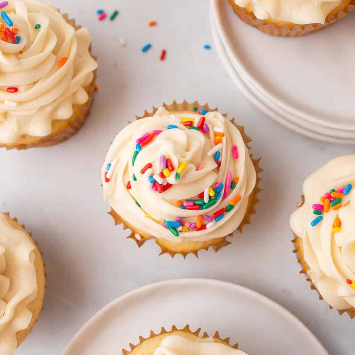 vanilla cupcake with frosting and colorful sprinkles