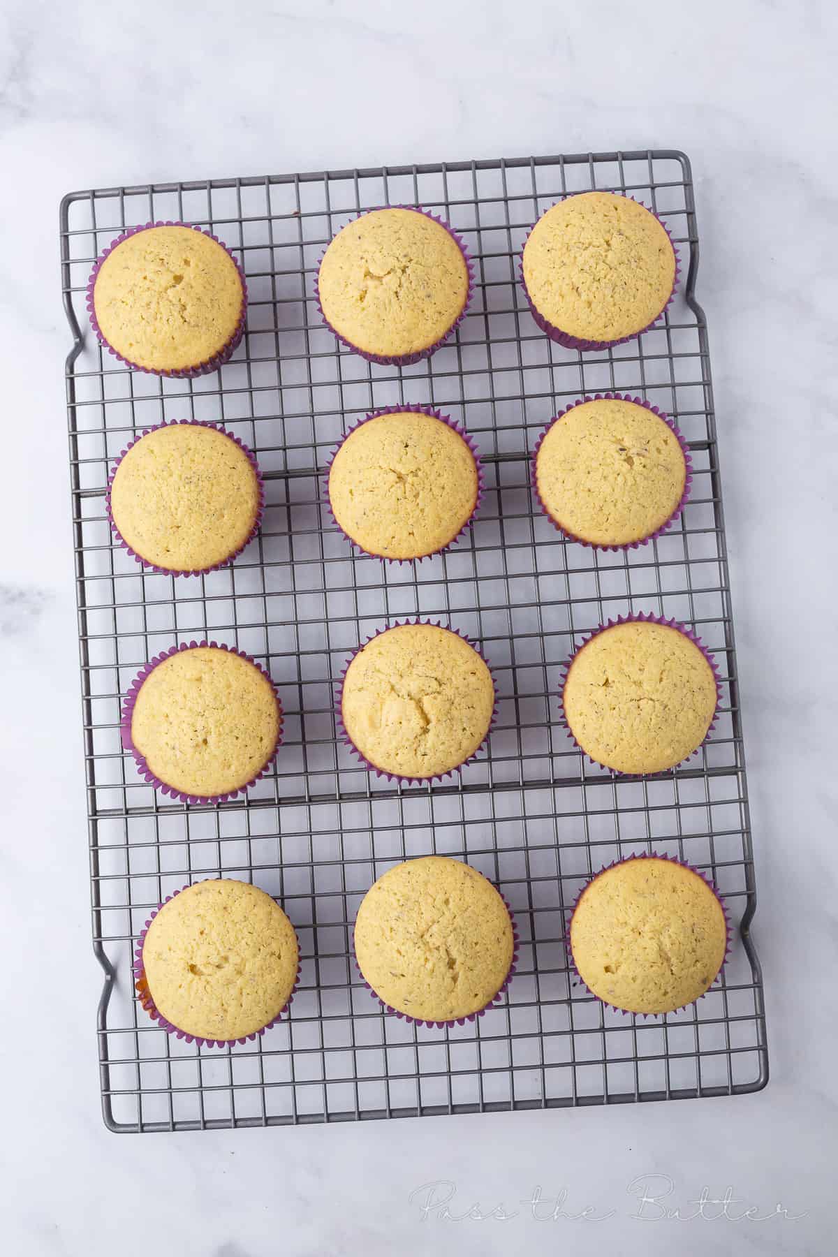 Baked cupcakes cooling on a wire rack.