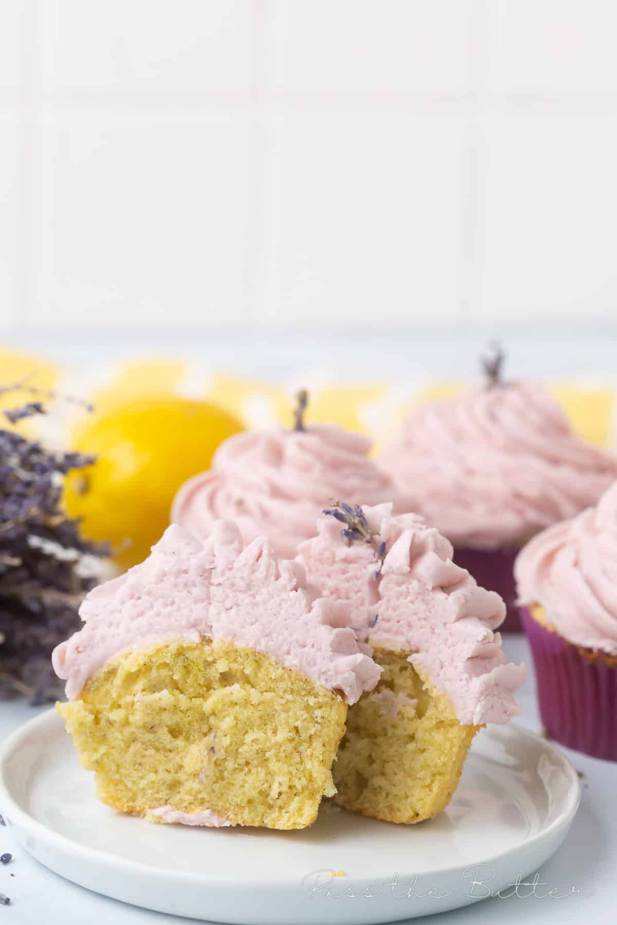 lavender cupcakes on a marble countertop. One is cut in half.